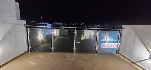 a glass balcony with a view of a city at night at Seahawk Plateau 3A Apt on Rua Pedonal Praia Cape Verde in Praia