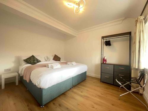 een slaapkamer met een bed met een spiegel en een stoel bij Private 2 Bed Guest House - Van Parking, M25 & A1 connections in Potters Bar