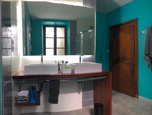 une salle de bain avec deux lavabos et un grand miroir dans l'établissement Chez Paul, à Saint-Mard-de-Vaux