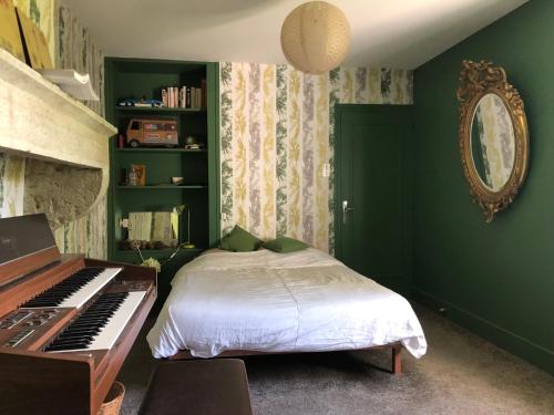 - une chambre verte avec un lit et un piano dans l'établissement Chez Paul, à Saint-Mard-de-Vaux