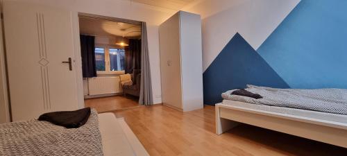 a room with two beds and a blue wall at Private Wohnung in Leimen in Leimen