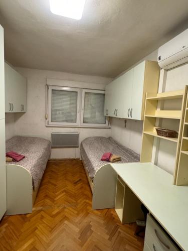 Kleines Zimmer mit 2 Betten und einem Schreibtisch. in der Unterkunft Apartman Sunnyplace in Mostar