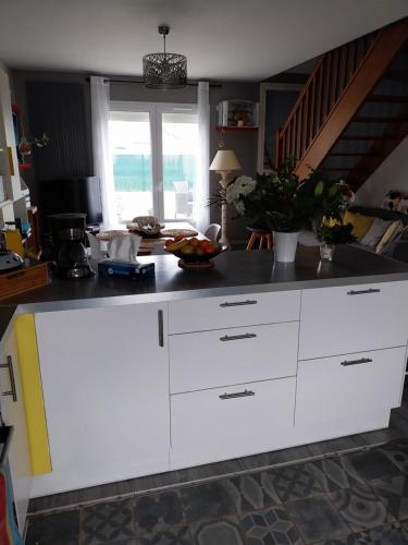 eine Küche mit weißen Schränken und einer Arbeitsplatte in der Unterkunft Maison Marinette in La Turballe