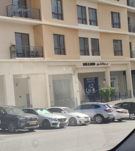 een groep auto's geparkeerd voor een gebouw bij Badr alqurm in Wuţayyah