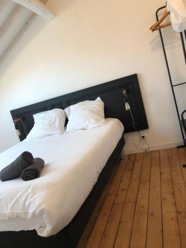 Un dormitorio con una cama grande con cabecero negro. en Appartement Art moderne entre Disney et Paris, en Lagny