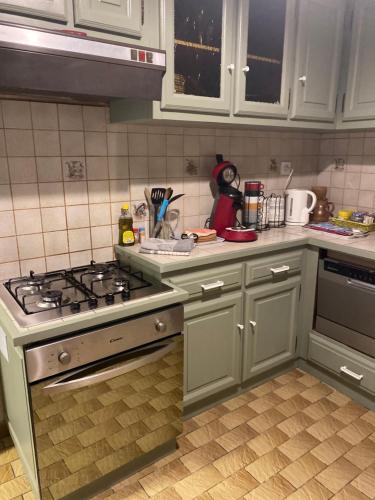 uma cozinha com armários brancos e um forno com placa de fogão em Notre chez nous pour vous em Fourchambault