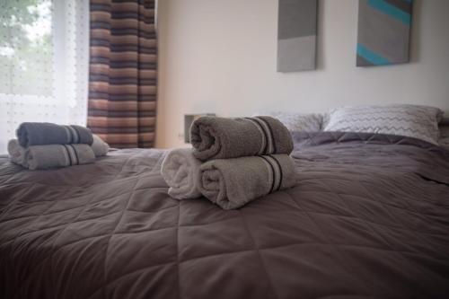 a bed with two towels on top of it at Kincses Vendégház in Senta