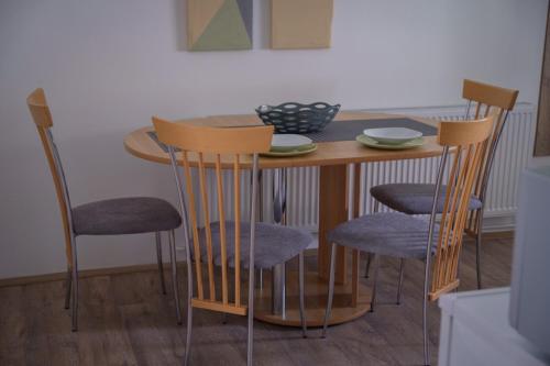 a dining room table with four chairs around it at Kincses Vendégház in Senta