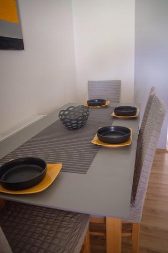 a table with black plates and yellow chargers on it at Kincses Vendégház in Senta