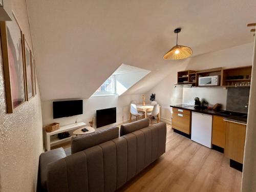 un salon avec un canapé et une cuisine dans l'établissement Douce Agathe - Duo-Groupe, Chaleureux, Tram 200m, Centre 10min, à Strasbourg