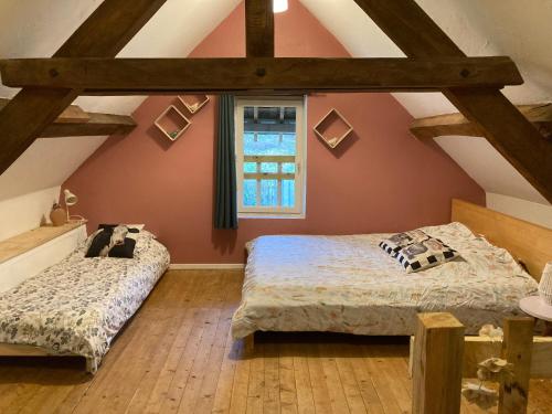 Schlafzimmer im Dachgeschoss mit 2 Betten und einem Fenster in der Unterkunft Maison, Le Champ du Rossignol in Beuvron-en-Auge