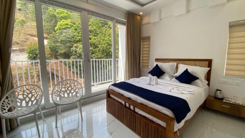 a bedroom with a bed and a balcony with windows at Akai Vibe in Munnar