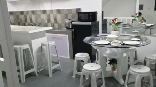 a kitchen with a table and stools in it at ERVORUTO HOSTEL 23 Makati in Manila