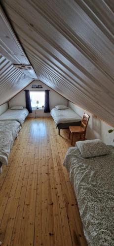 een kamer met 4 bedden en een houten vloer bij Arctic Cottage Kiruna, Groups in Kiruna