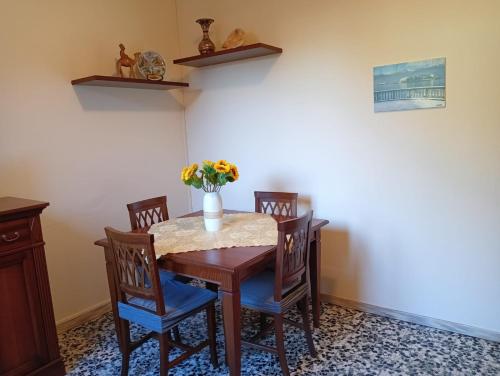 a dining room table with chairs and a vase of flowers at Casa Margherita - bike friendly in Verbania