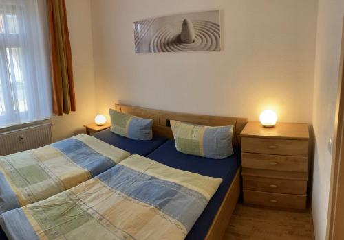 um pequeno quarto com 2 camas e uma cómoda em Ferienwohnung Auszeit em Bad Berka