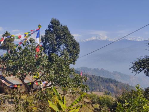 a flag on a hill with mountains in the background at Hotel Gogreen Kattike Pvt. Ltd. in Nagarkot