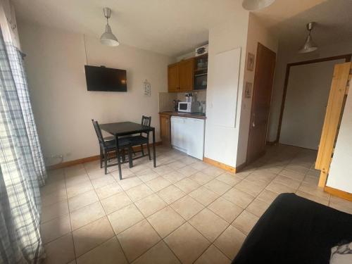 une cuisine et une salle à manger avec une table et des chaises dans l'établissement Petit Praz, à Praz-sur-Arly