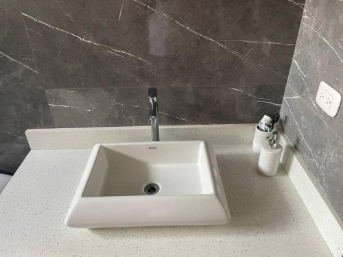 a bathroom sink with a faucet on a counter at Alojamiento Kim House Orotina in Orotina