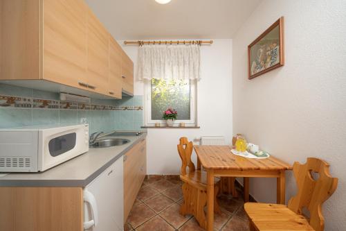una piccola cucina con tavolo e forno a microonde di Rooms & Apartments Pr Matjon a Bled