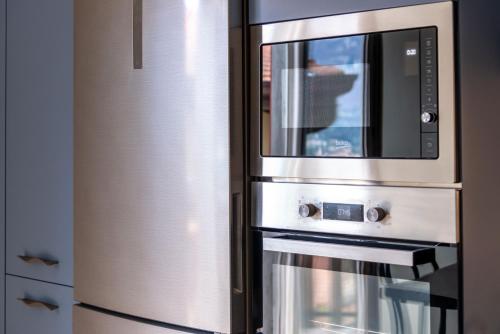 a stainless steel microwave oven sitting next to a refrigerator at New stone house lake view - 2 in Lezzeno