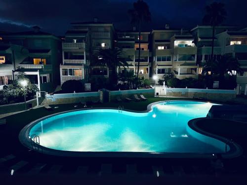 アロナにあるChayofa Country Clubの夜間の一部の建物の前にある大きなスイミングプール