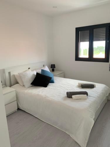 Un dormitorio con una gran cama blanca con almohadas. en Maison de vacances, en Pombal