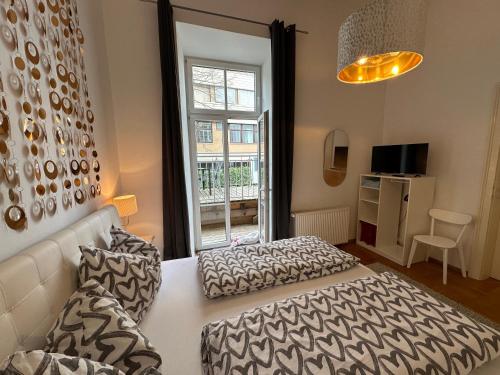 a bedroom with a bed and a couch and a window at Apartment-Zimmer KRISTALL - großer Balkon und Parkplatz direkt im Zentrum in Bad Ischl