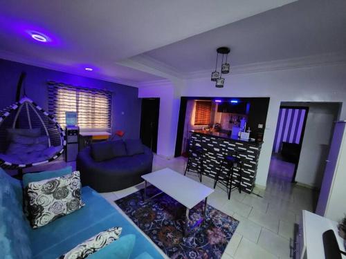 a living room with a couch and a table at Asfranz Apartment Luxury One-Bedroom with Private Garden in Abuja