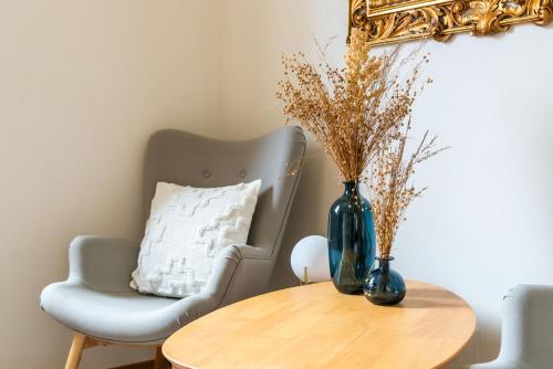 a table with a chair and a vase on it at New stone house lake view - 2 in Lezzeno