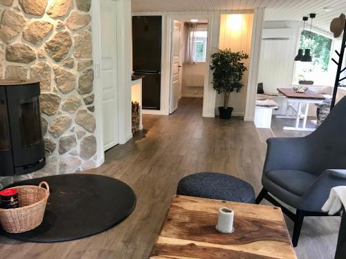 a living room with a stone fireplace and a table at Nordic Relax House - Stonehouse in Sjöbo