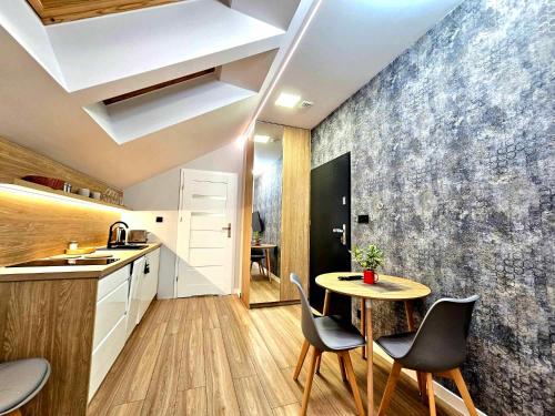 a kitchen with a table and chairs in a kitchen at Apartamenty na 102 in Iława