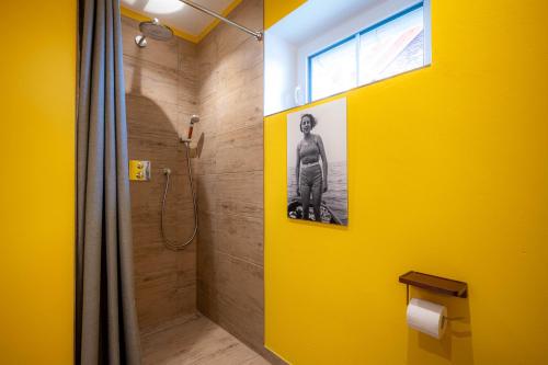 a bathroom with a shower with a yellow wall at Ferienhaus Lee in Pellworm