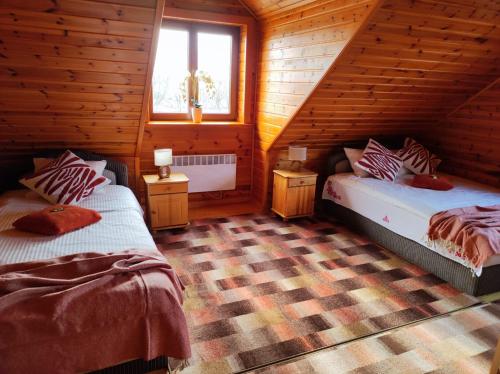 sypialnia z 2 łóżkami w drewnianym domku w obiekcie DANIELSJA 