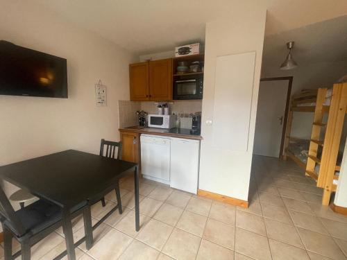 une petite cuisine avec une table et un micro-ondes dans l'établissement Petit Praz, à Praz-sur-Arly