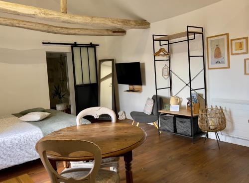 1 dormitorio con 1 cama, mesa y sillas en Studio la Grange en Fontevraud-l'Abbaye