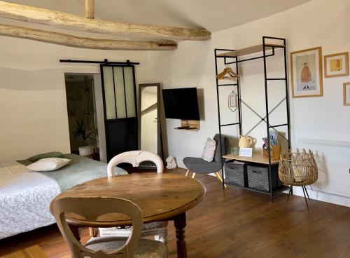 a bedroom with a bed and a table and chairs at Studio la Grange in Fontevraud-l'Abbaye