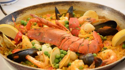 a pan of food with a lobster and vegetables at Adria Hotel and Conference Center in Queens