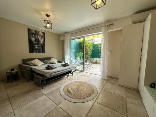 une chambre avec un lit et une grande fenêtre dans l'établissement COSY MADRID, appartement proche de la mer, à Cannes