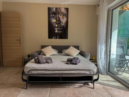 1 dormitorio con 1 cama con una foto en la pared en COSY MADRID, appartement proche de la mer, en Cannes