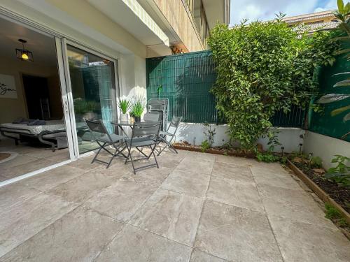 un patio con sillas y una mesa en un porche en COSY MADRID, appartement proche de la mer, en Cannes