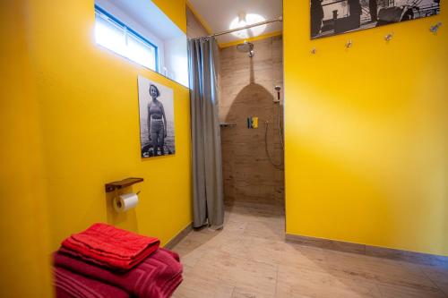 uma casa de banho com uma parede amarela e um chuveiro em Ferienhaus Luv em Pellworm