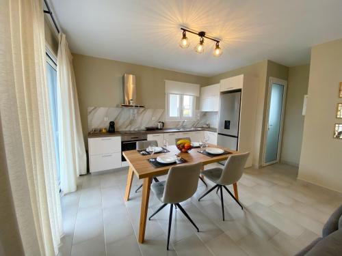 - une cuisine et une salle à manger avec une table et des chaises dans l'établissement Taras Residence, à Karavádhos