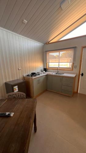 a large kitchen with a stove and a window at Pewma Apart Hotel in Chillán