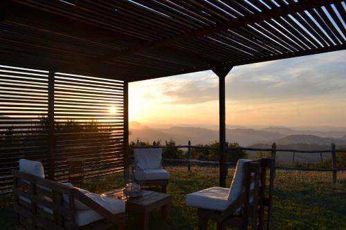a patio with two chairs and a table with a view at Fattoria Bio L'A Ceccoli in Sassofeltrio