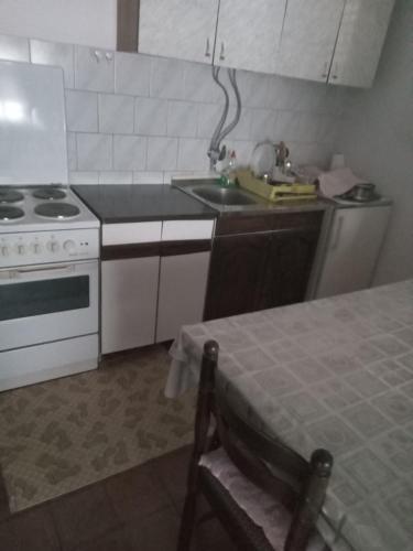 uma cozinha com um lavatório e um fogão forno superior em Janina Hiša em Stolac