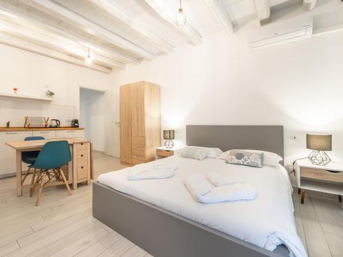 a bedroom with a large bed and a desk at La Dolce Cagliari holiday home in Cagliari