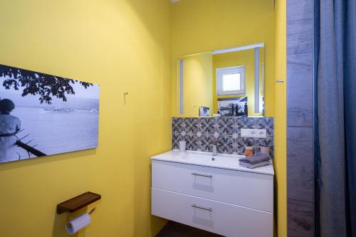 ein gelbes Badezimmer mit einem Waschbecken und einem Spiegel in der Unterkunft Cabin in Pellworm