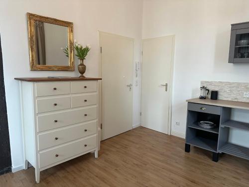 1 dormitorio con tocador blanco y espejo en Toscana en Lübeck