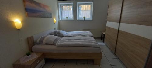 two beds in a room with two windows at Ferienwohnung Altstadt-Domizil Hameln in Hameln